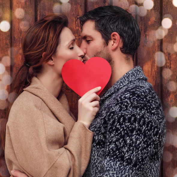 Couple kissing behind a heart